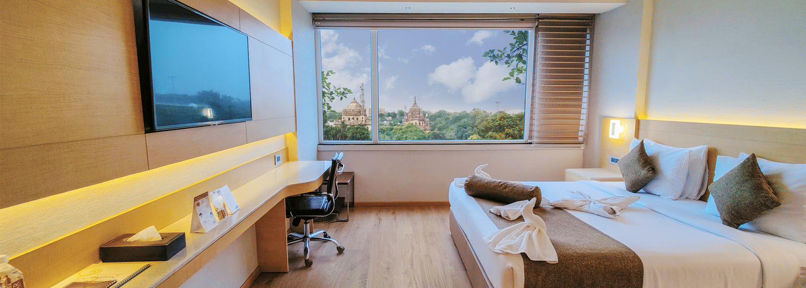 An overview of the Suite at Gemini Continental with a king bed and a tv opposite it.